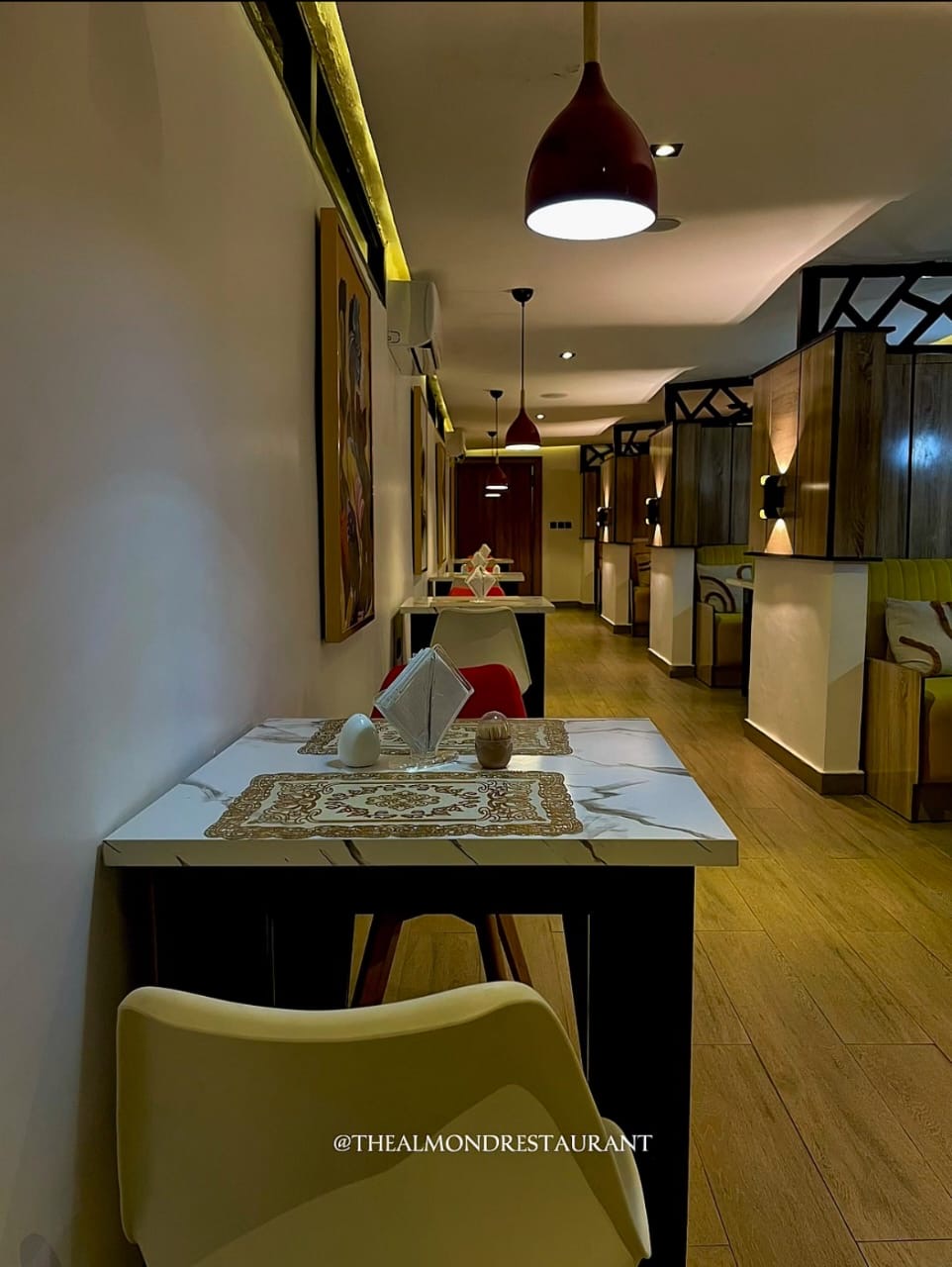 The Almond Restaurant dining room interior — warm lighting and red pendant lamps